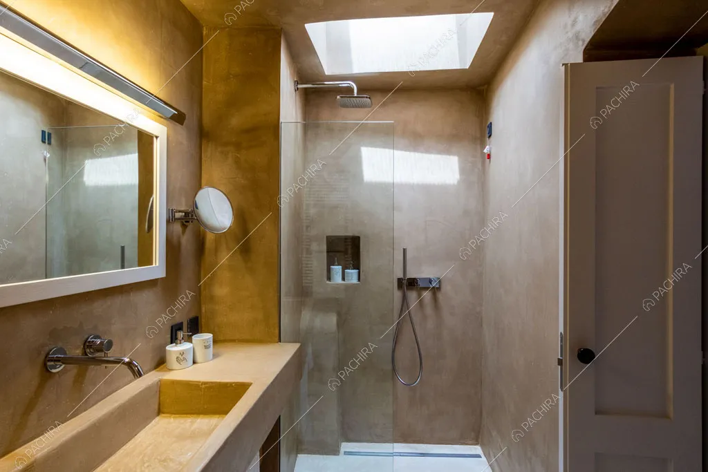 Box doccia con lucernario e lungo lavandino nel bagno privato