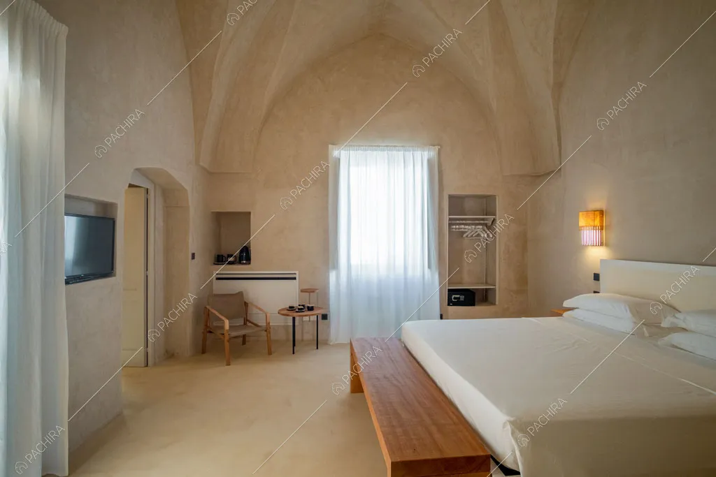 Grande camera da letto matirmoniale con panca in legno e soffitto a volte