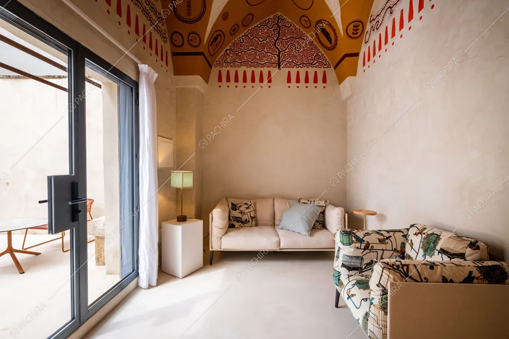 Luminoso salotto con soffitto decorato in stile etnico e porta-finestra