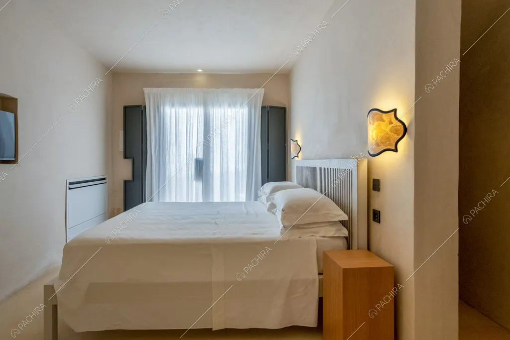 Porte-finestre riempiono di luce naturale la camera da letto matrimoniale