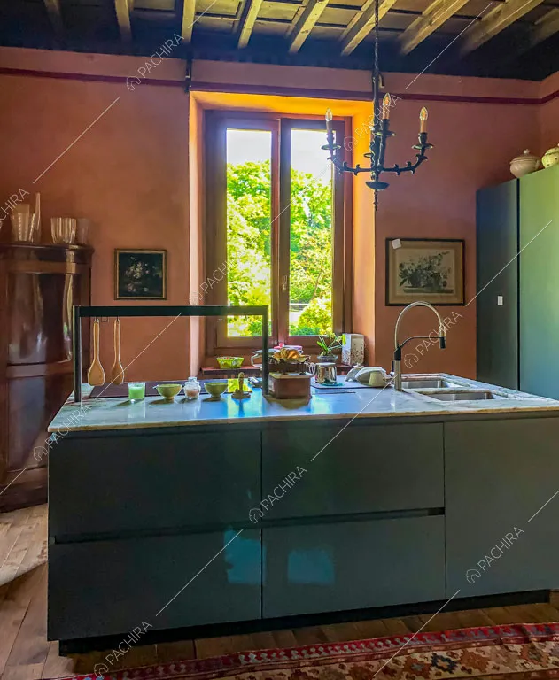 Grande isola della cucina riempita di luce naturale e soffitto a cassettoni