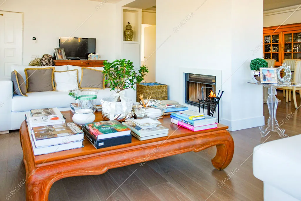 Tavolino in legno nella zona living con camino e pavimento in parquet