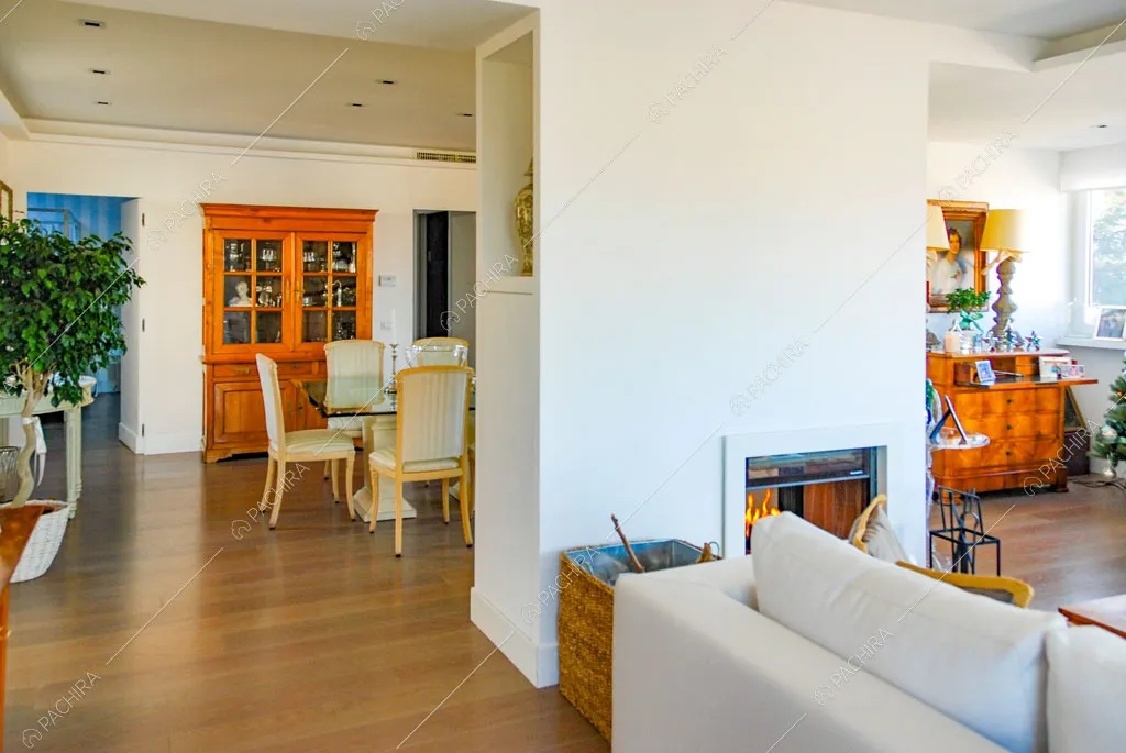 Luminosa zona living con pareti bianche, pavimento in parquet e tavolo da pranzo