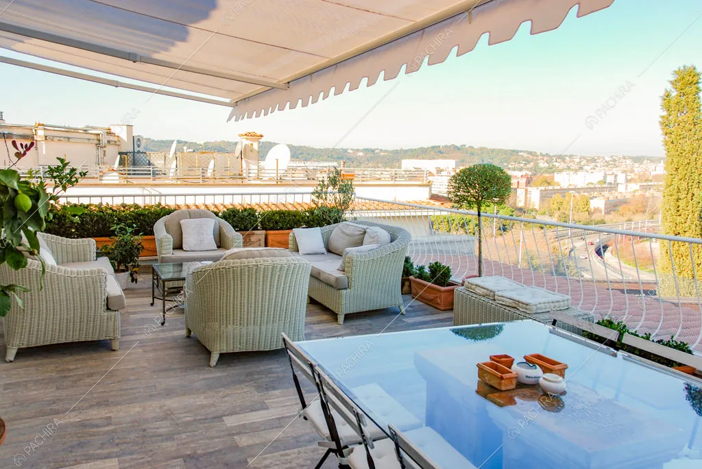 Terrazza con vista sulla città, tavolo da pranzo da esterni e poltrone in vimini