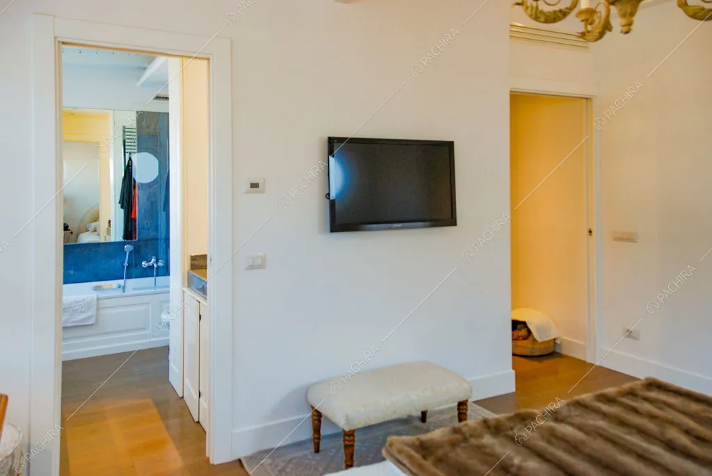 Camera da letto matrimoniale con pareti bianche e vista sul bagno privato