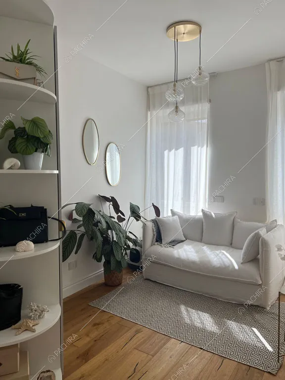Divano bianco nella sala dell'appartamento Granadella, location in stile contemporaneo a Roma