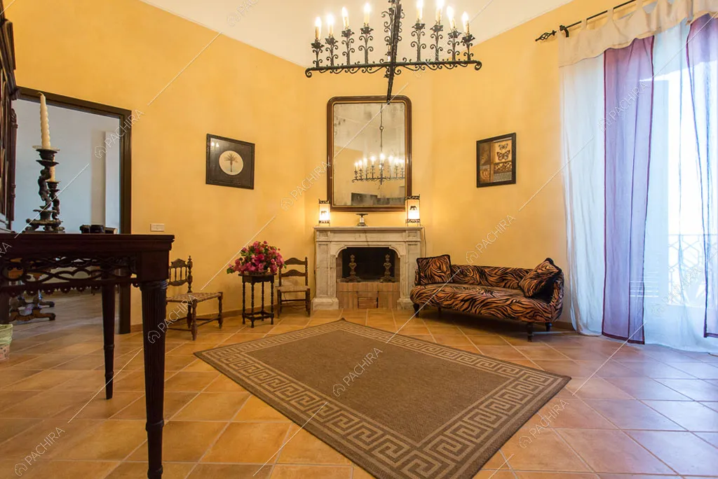 Salotto con pareti gialle e camino nel castello Cambay, location in stile classico a Caltanissetta