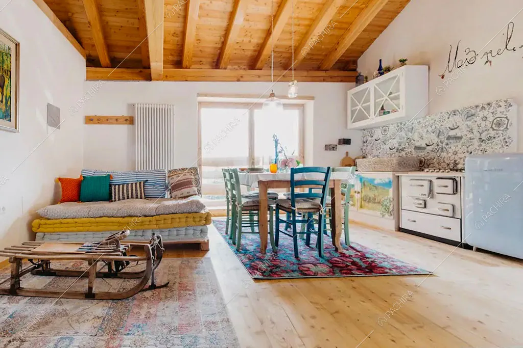 Zona living con cucina a vista dello chalet Timor, location in stile rustico a Trento