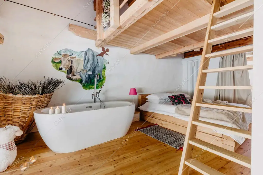 Camera da letto con vasca da bagno nello chalet Timor, location in stile rustico a Trento