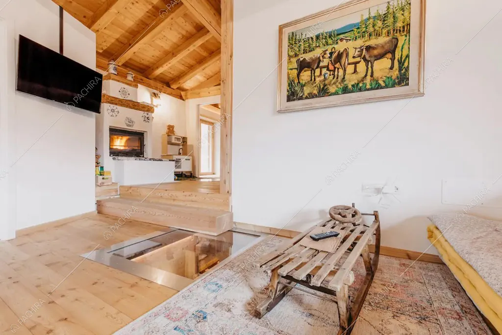 Salotto con pavimento in parquet dello chalet Timor, location in stile rustico a Trento