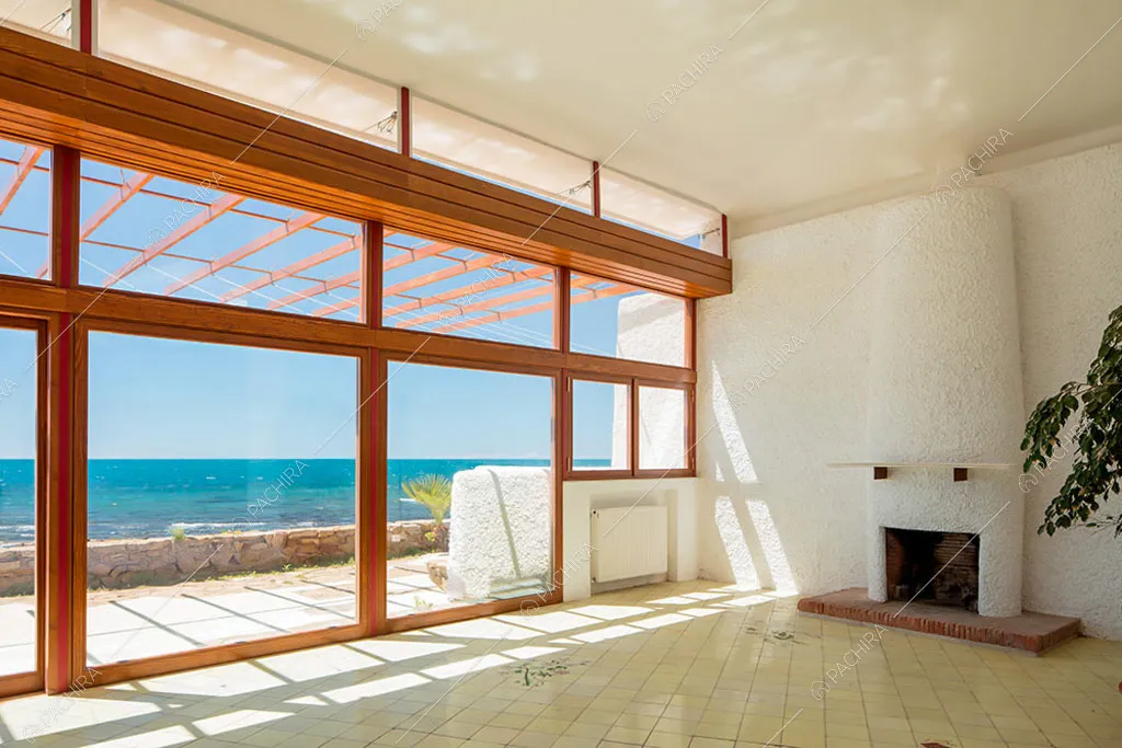 Sala con camino e vista sul mare tramite le vetrate nella villa Libeccio, location in stile moderno a Roma