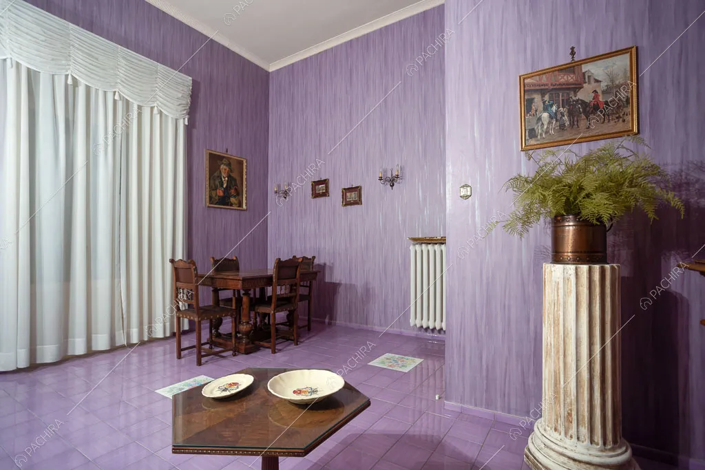 Stanza con tavolo da pranzo e pareti lilla della dimora storica Romero, location in stile classico a Campobasso