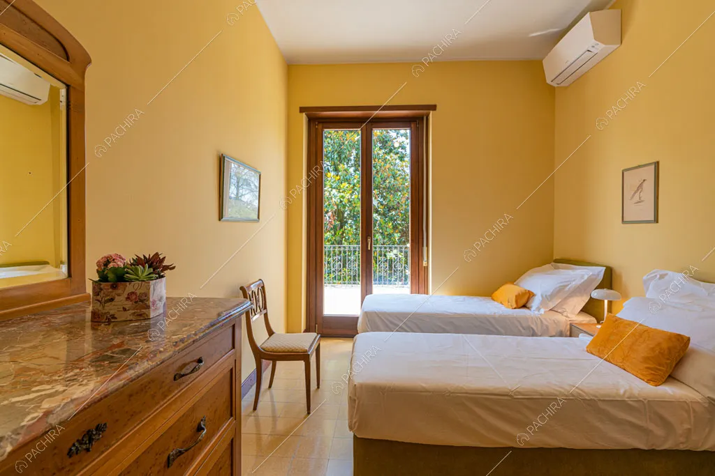 Camera da letto con pareti gialle della villa Ramaria, location in stile classico a Ravenna