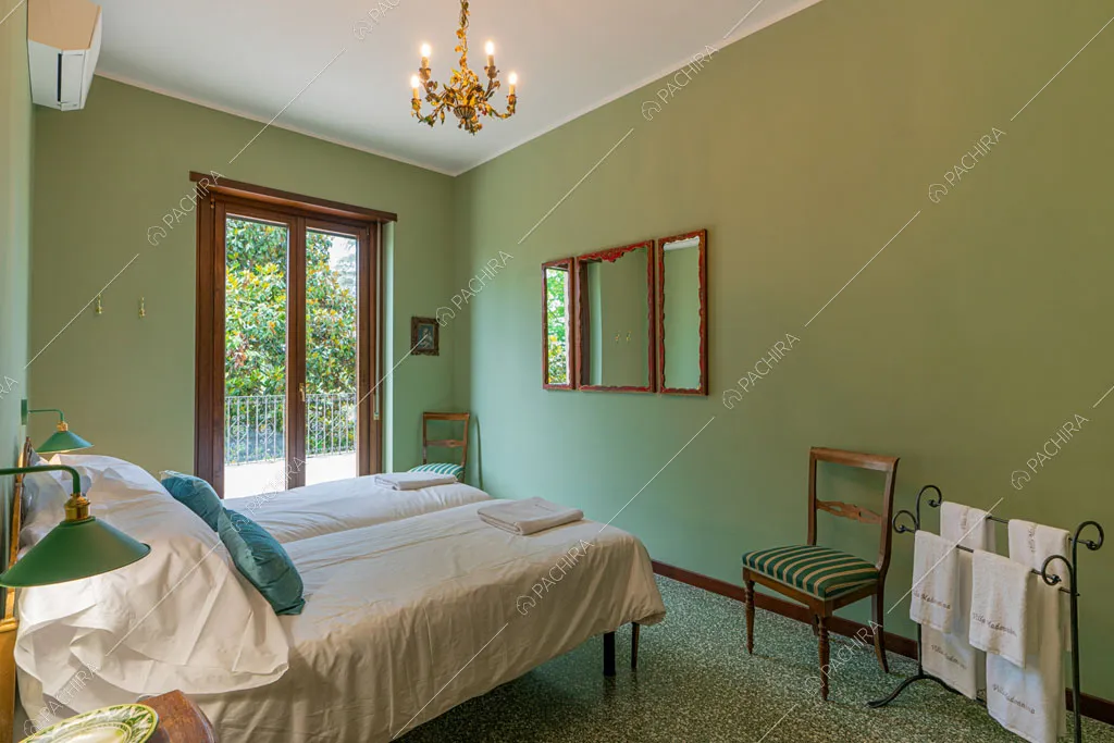 Camera da letto con pareti verdi della villa Ramaria, location in stile classico a Ravenna