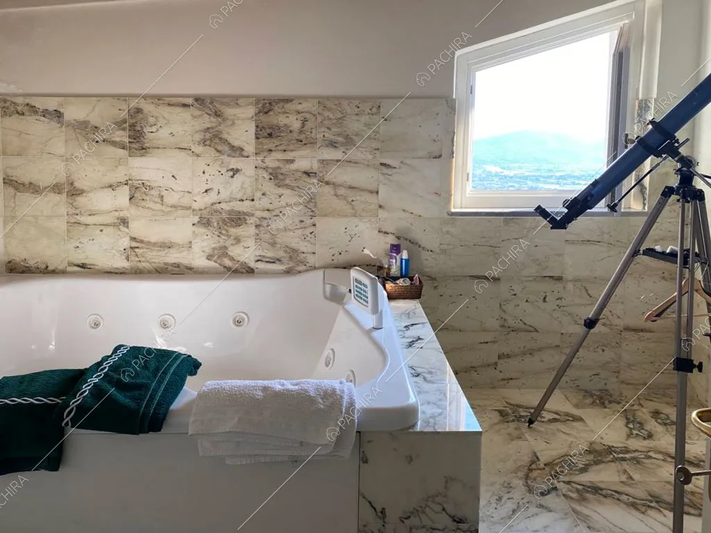 Bagno con vasca idromassaggio e pavimento in marmo della villa Nyiri, location in stile moderno a La Spezia