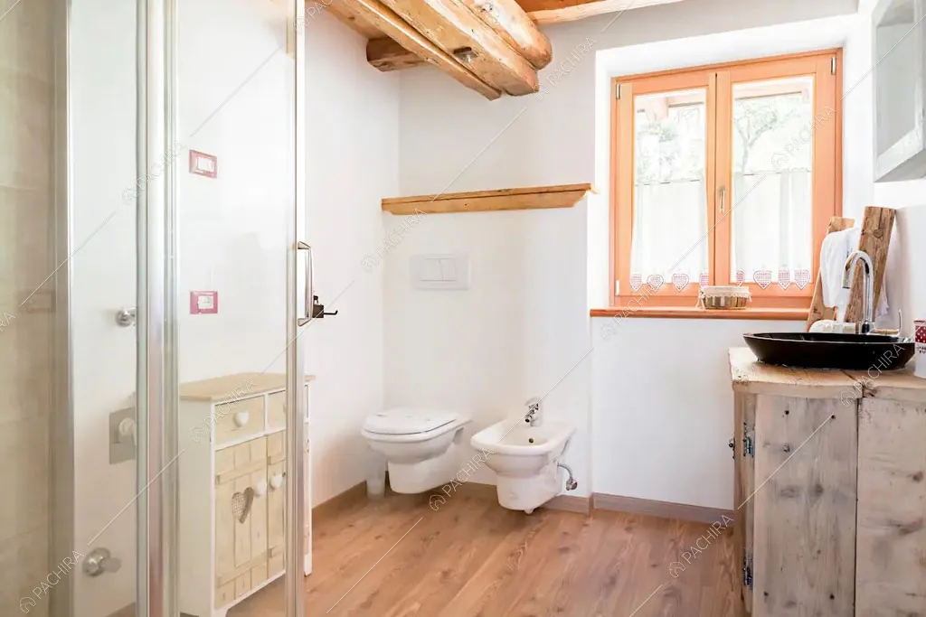Bagno con pavimento in parquet dello chalet Cantabrico, location in stile rustico a Trento
