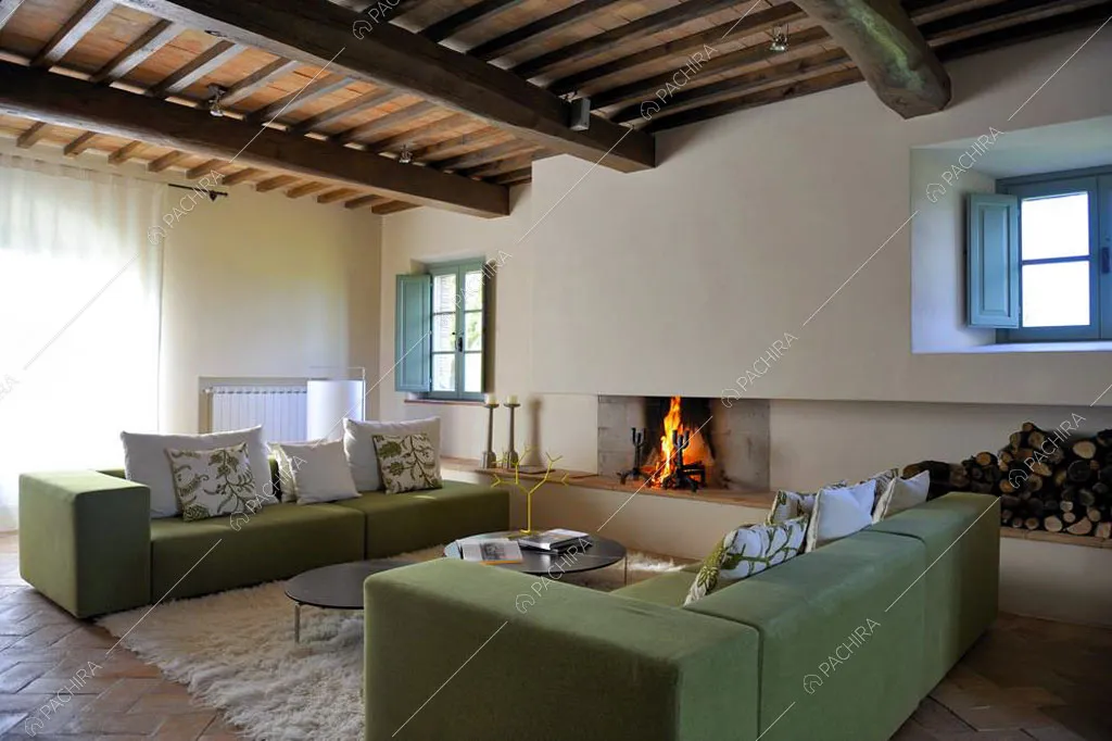 Zona living con travi a vista sul soffitto della villa Monegros, location in stile contemporaneo a Viterbo