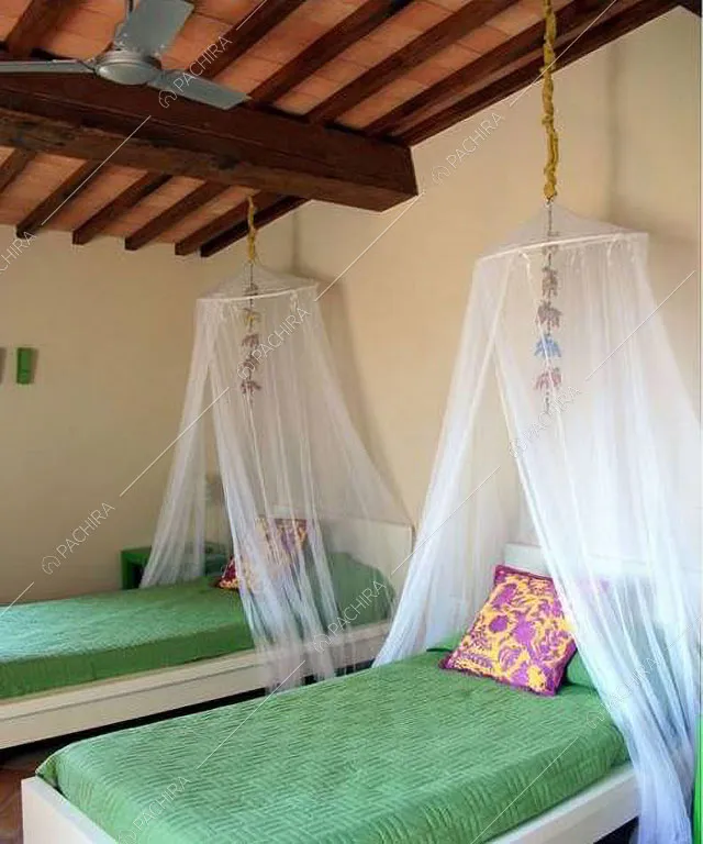 Letti singoli nella camera con travi a vista sul soffitto nella villa Monegros, location in stile contemporaneo a Viterbo