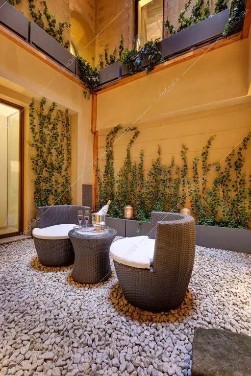 Giardino e vista sugli esterni gialli dell'appartamento Passiflora, location in stile contemporaneo a Roma