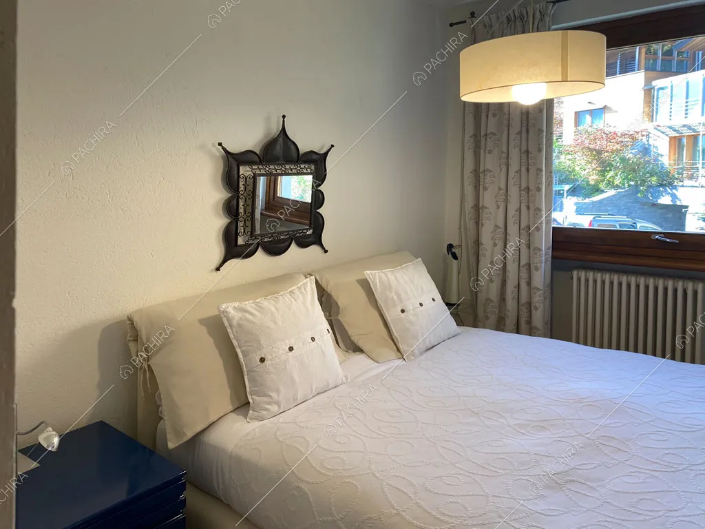 Camera da letto matrimoniale con pareti bianche della villa Aqaba, location in stile contemporaneo ad Aosta