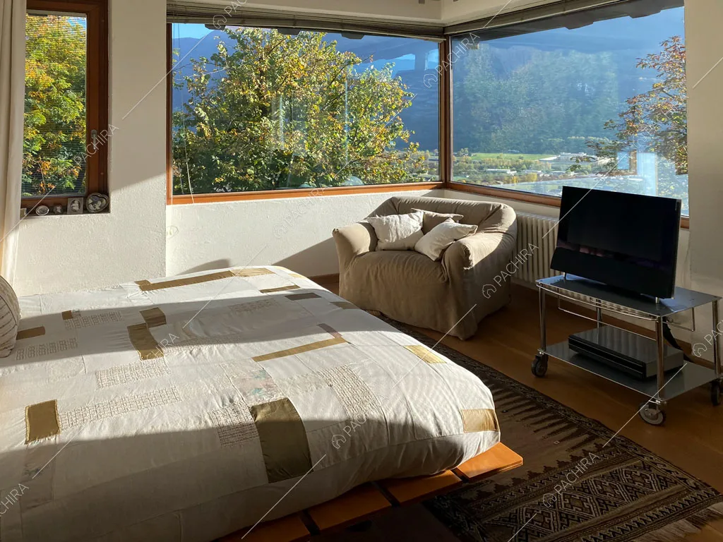 Camera da letto con vetrate della villa Aqaba, location in stile contemporaneo ad Aosta