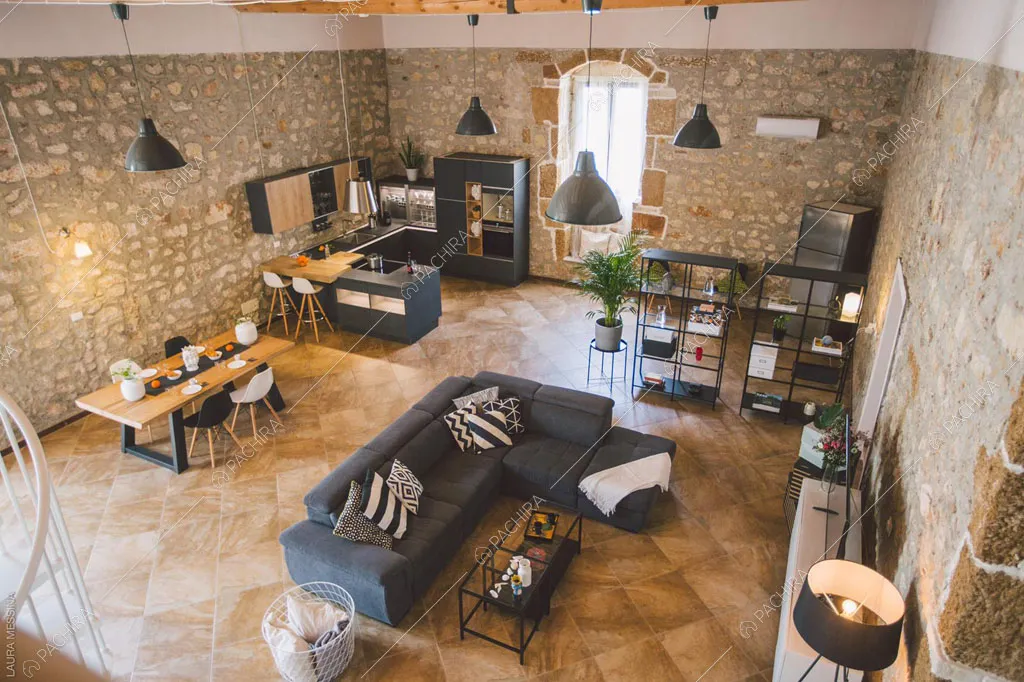 Pareti in pietra a vista della sala della villa Hibiki, location in stile moderno a Siracusa