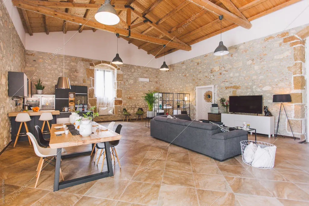 Travi in legno a vista sul soffitto della zona living della villa Hibiki, location in stile moderno a Siracusa