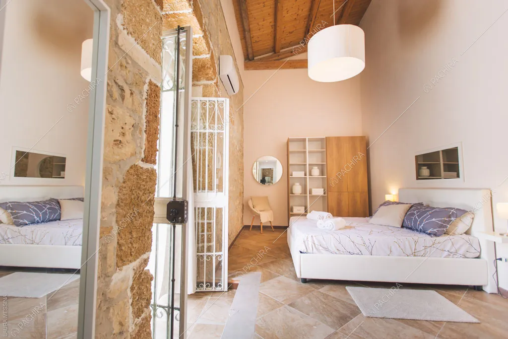 Travi in legno a vista sul soffitto della camera della villa Hibiki, location in stile moderno a Siracusa