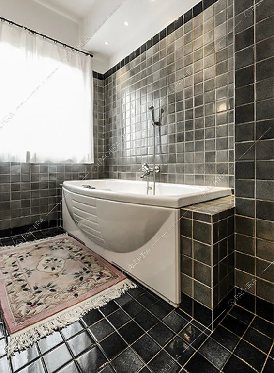 Bagno con piastrelle nere dello chalet Betel, location in stile rustico a Lecco