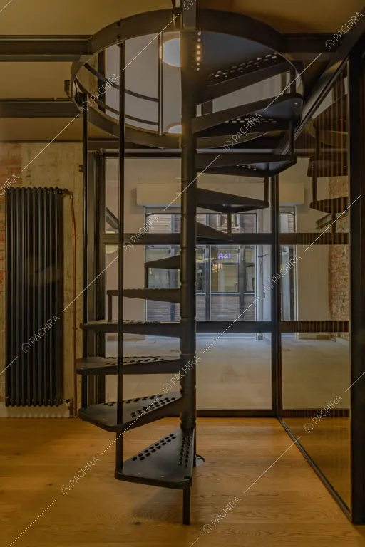 Pavimento in parquet e scala a chiocciola nell'atrio del loft Sechura, location in stile contemporaneo a Milano