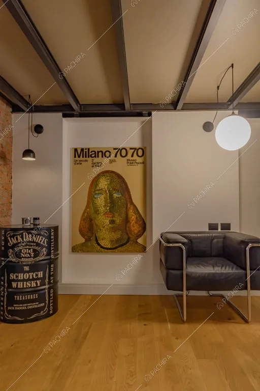 Salotto con travi in metallo a vista sul soffitto nel loft Sechura, location in stile contemporaneo a Milano