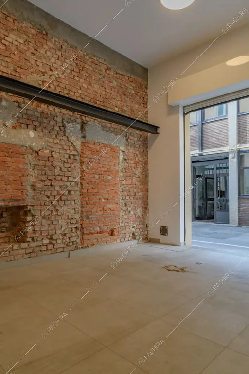 Parete in mattoni a vista all'ingresso del loft Sechura, location in stile contemporaneo a Milano