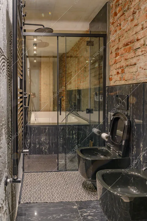 Bagno con pareti in marmo nero e in mattoni a vista del loft Sechura, location in stile contemporaneo a Milano
