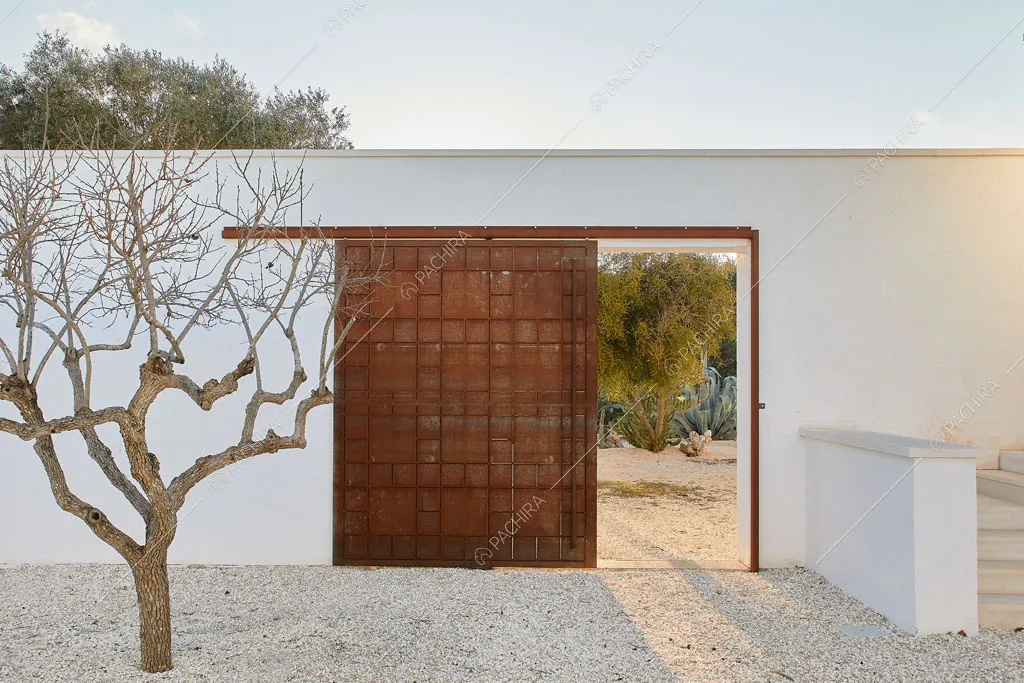 Porta scorrevole in legno nel giardino della masseria Ryn, location in stile contemporaneo a Brindisi