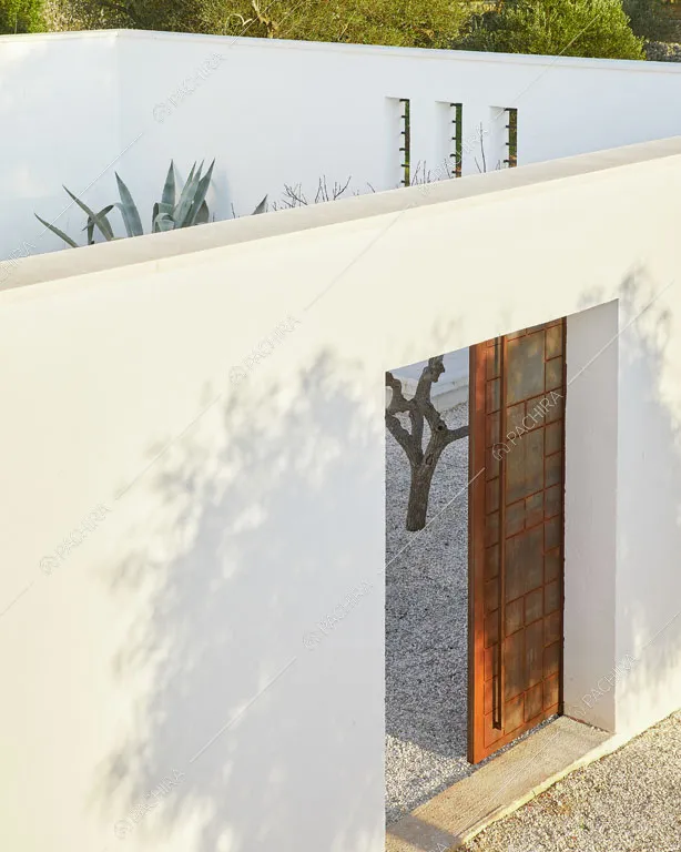 Mura bianche e porta scorrevole nel giardino della masseria Ryn, location in stile contemporaneo a Brindisi