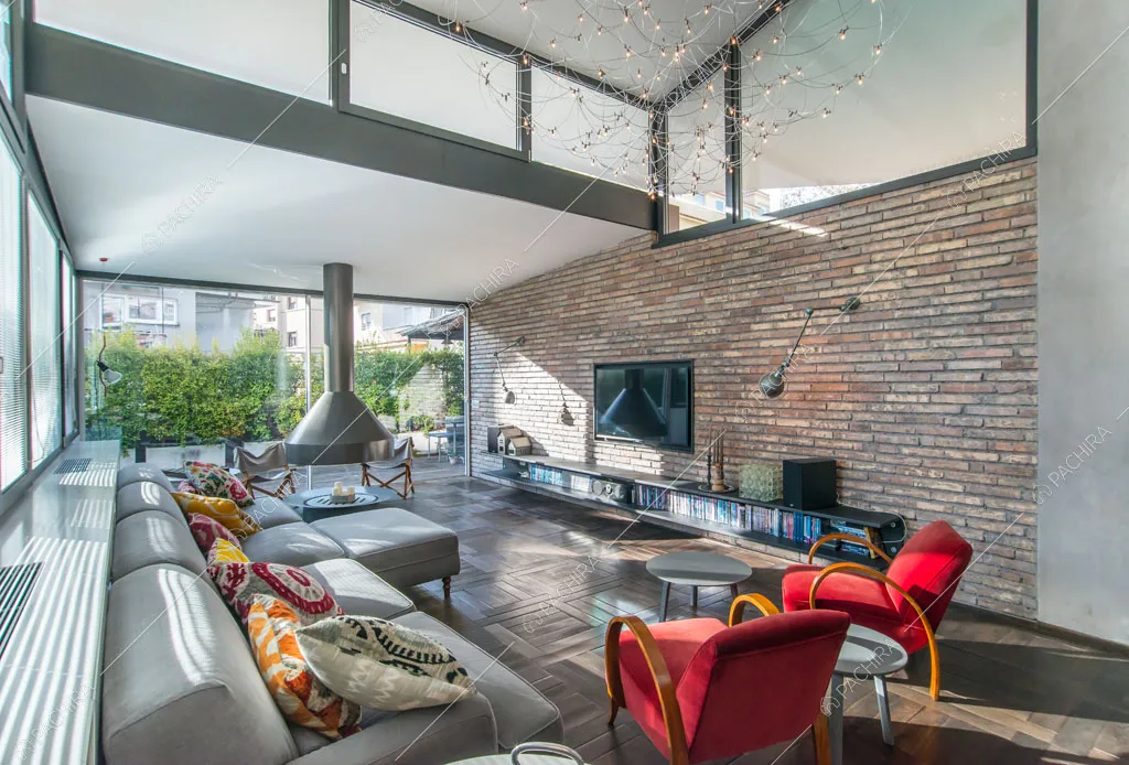 Camino e vetrate nella zona living dell'attico Karite, location in stile contemporaneo a Roma