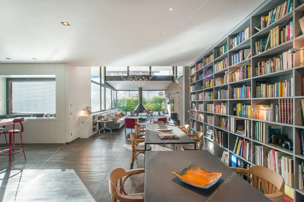 Zona living con pavimento in parquet e librerie dell'attico Karite, location in stile contemporaneo a Roma