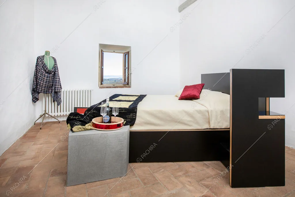 Camera da letto matrimoniale con pavimento in cotto della villa Bardenas, location in stile rustico a Siena