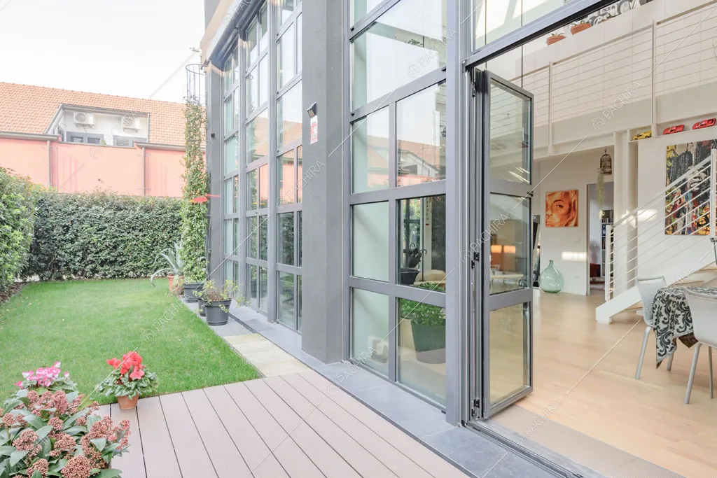 Dal giardino vista sulla zona living del loft Crisopazio, location in stile contemporaneo a Milano