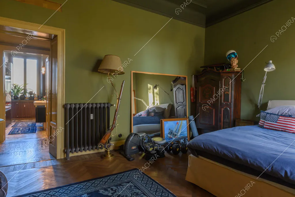 Camera da letto con pareti verdi dell'appartamento Garbino, location in stile classico a Milano