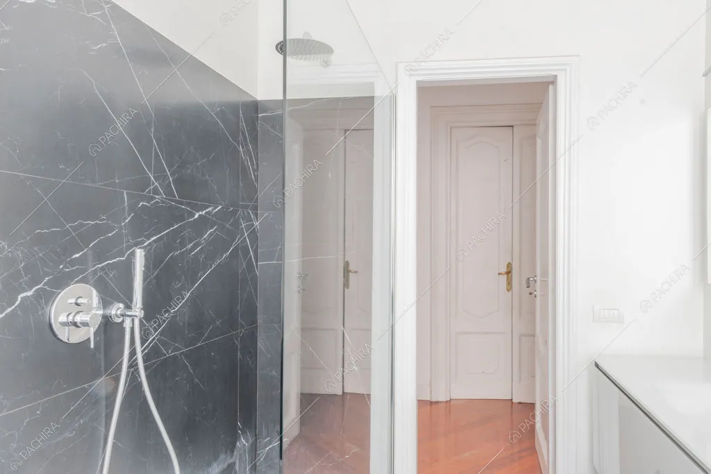 Parete in marmo nero nel bagno dell'appartamento Kiwano, location in stile moderno a Roma