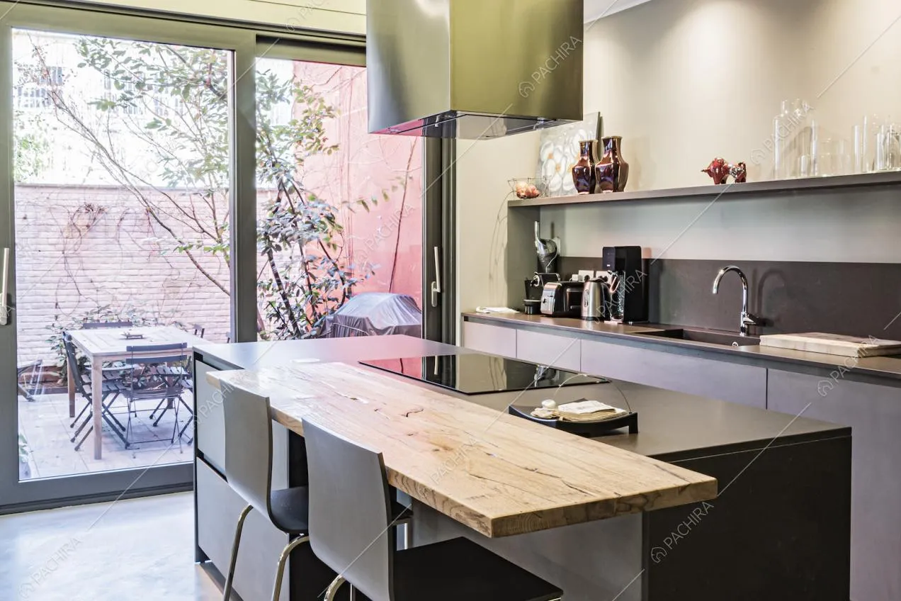 Cucina a isola moderna nei toni del grigio e terrazza con tavolo e sedie