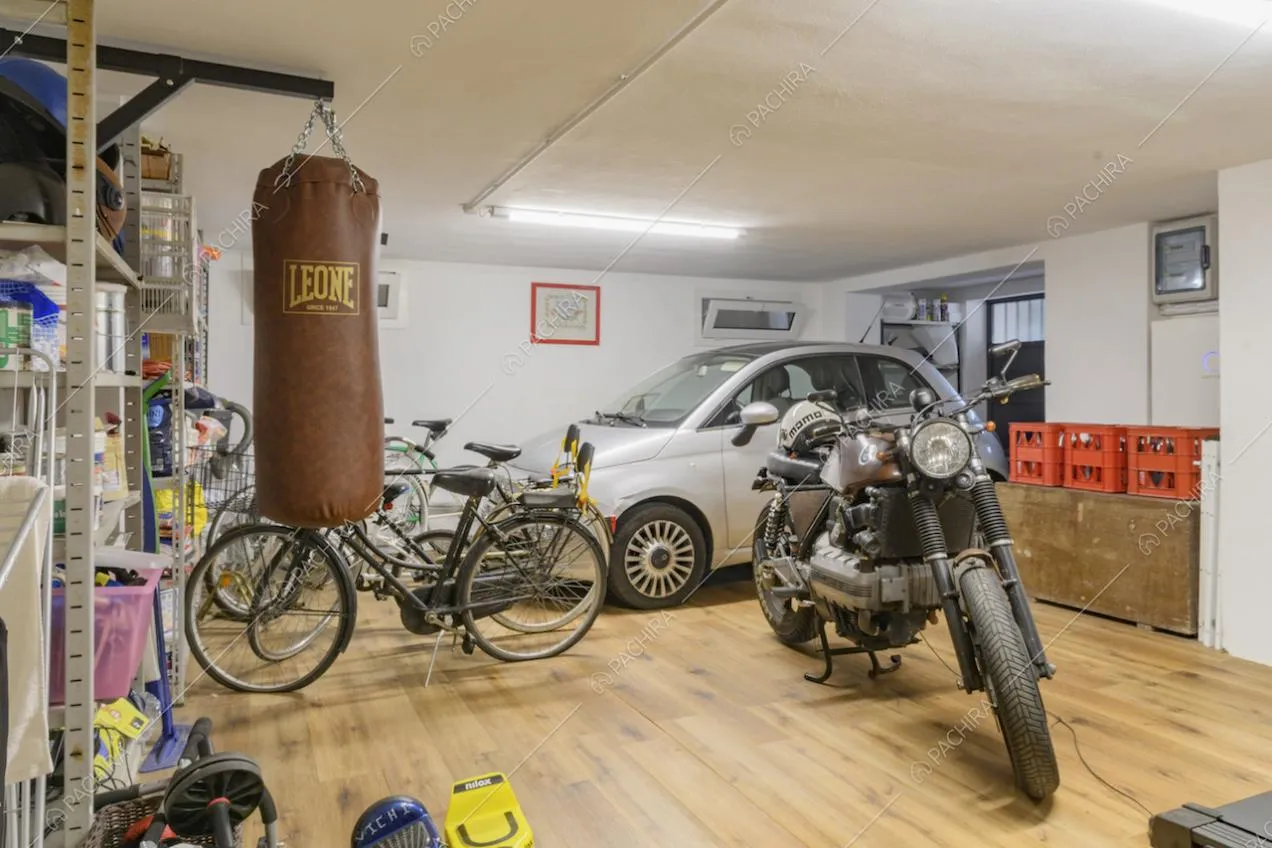 Sacco da boxe, biciclette, moto e auto nel garage