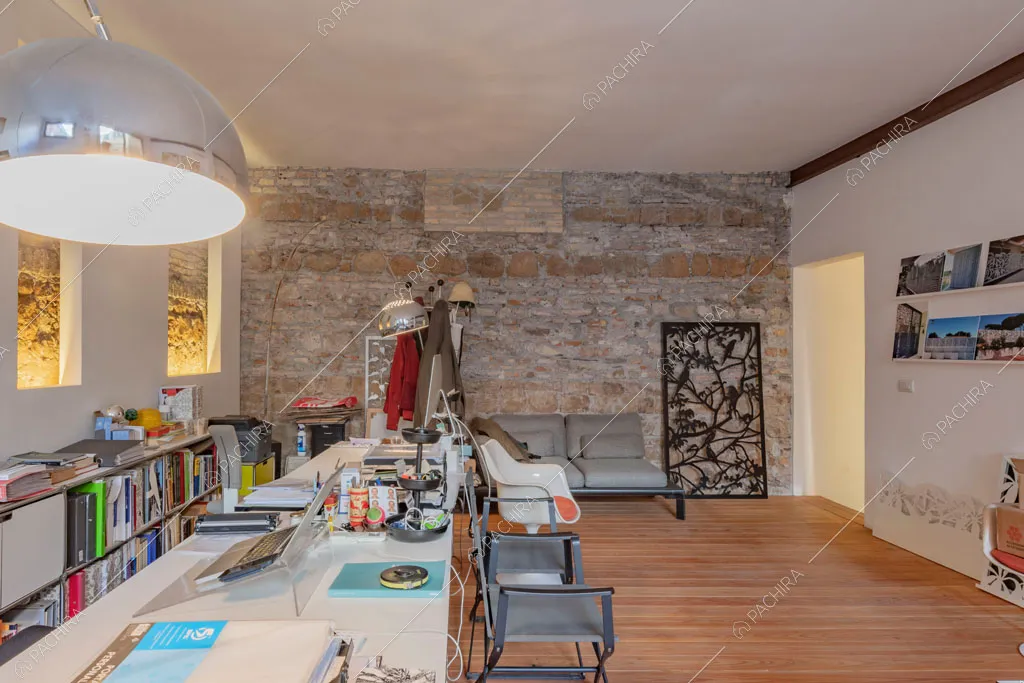 Sala con parete in pietra a vista nell'espositivo Couve, location in stile contemporaneo a Roma