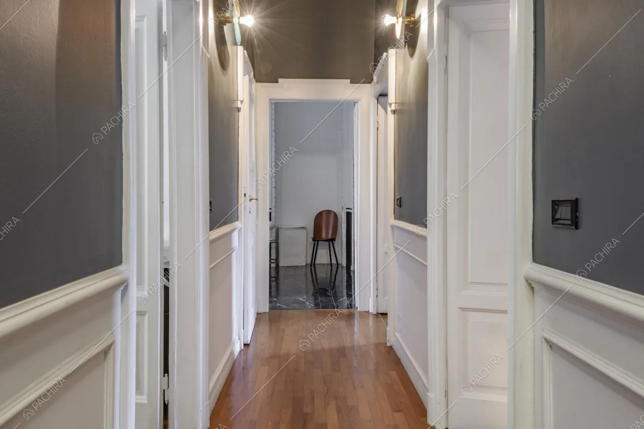 Corridoio con boiserie bianca e pareti color grigio