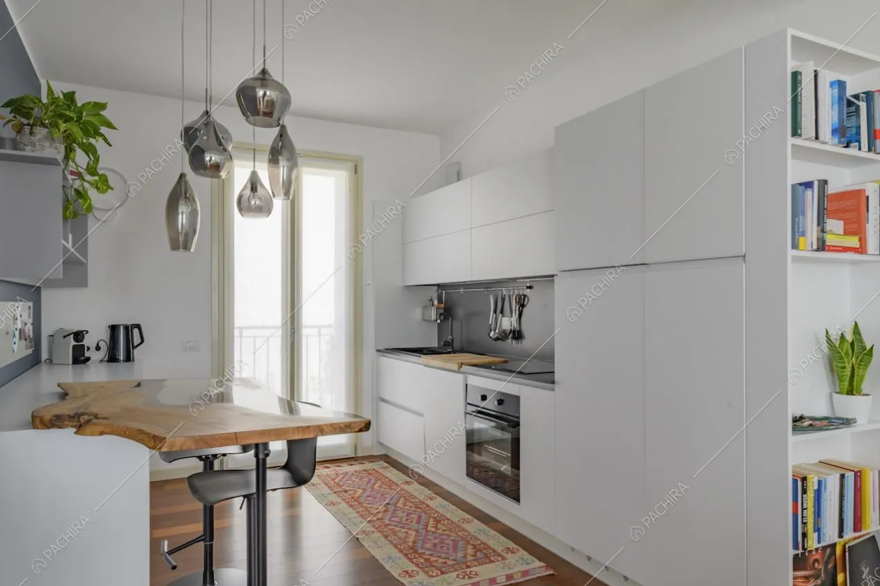 Cucina bianca a muro con bancone in legno e sgabelli
