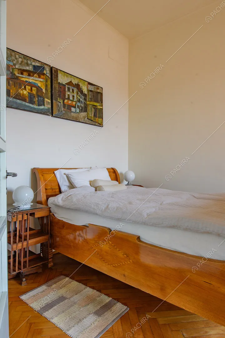 Pavimento in parquet a spina di pesce e pareti bianche nella camera da letto