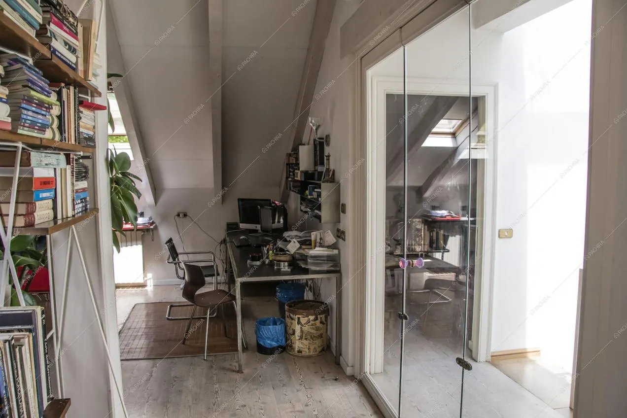 Scrivania nello studio con soffito in travi in legno a vista e pavimento in parquet