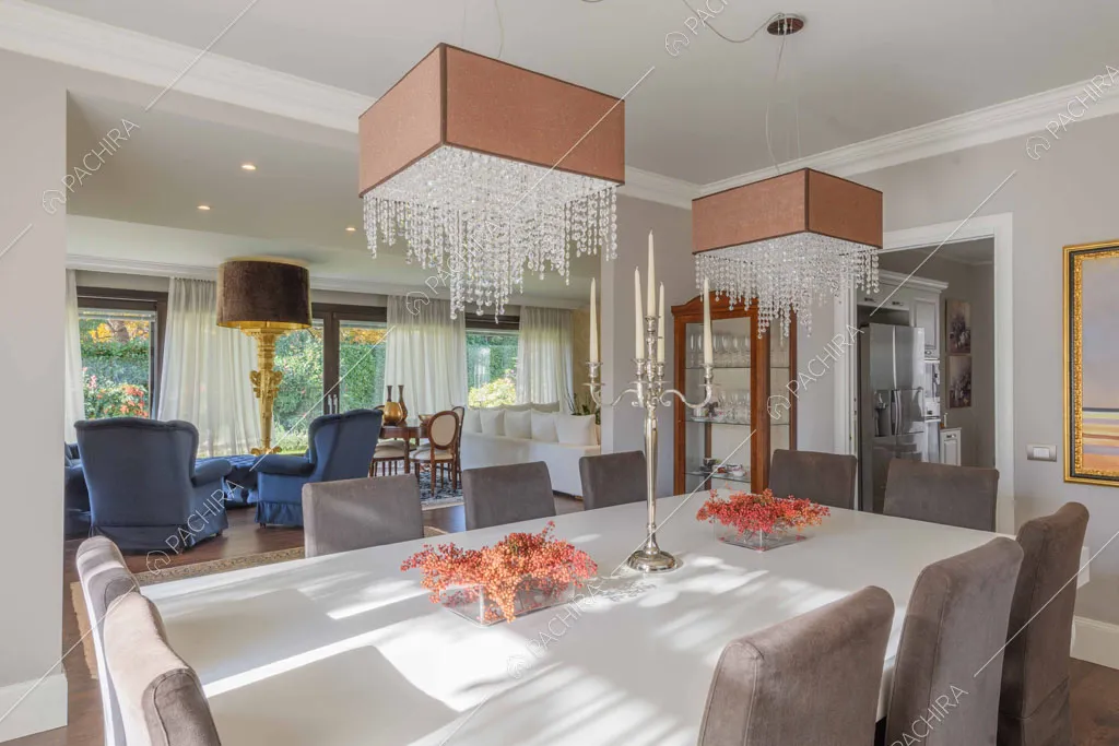 Tavolo da pranzo bianco con vista sulle poltrone azzurre e sui lampadari
