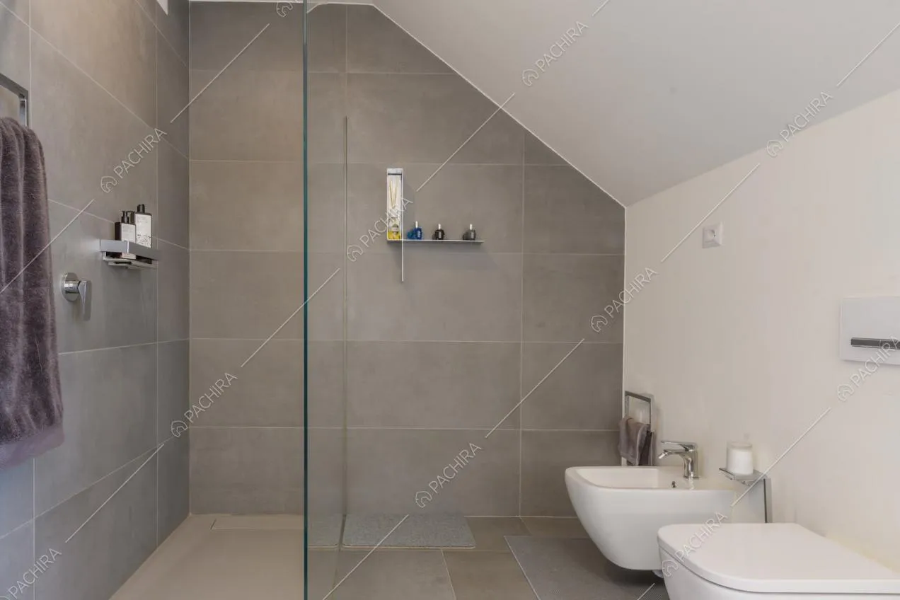 Bagno con grande box doccia dalle pareti in piastrelle grigie